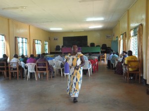 Ma Yuliana serves tea at a public planning meeting before the ICS volunteers arrived
